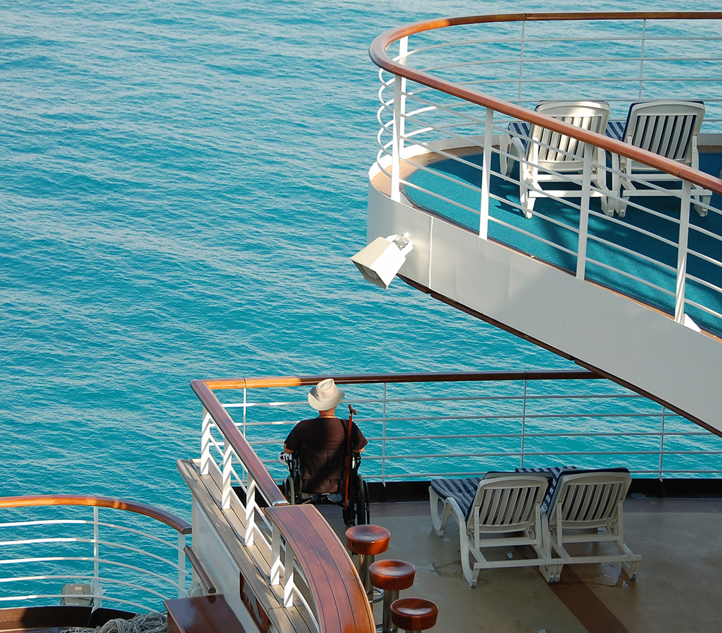 Man wearing a cowboy hat in a wheelchair enjoying time on a cruise ship