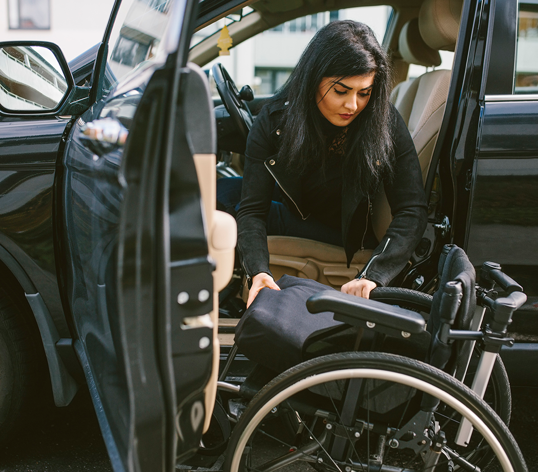 Woman transferring from car to wheelchair