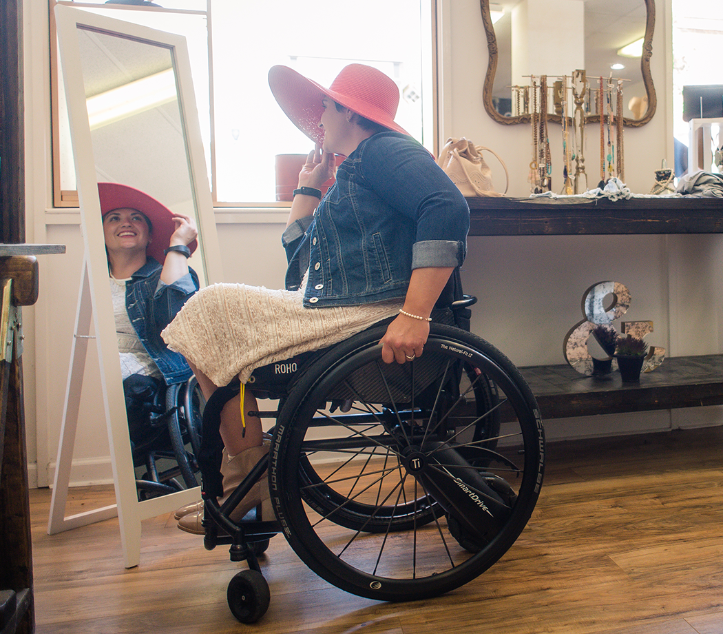 Woman in a wheelchair trying on a hat
