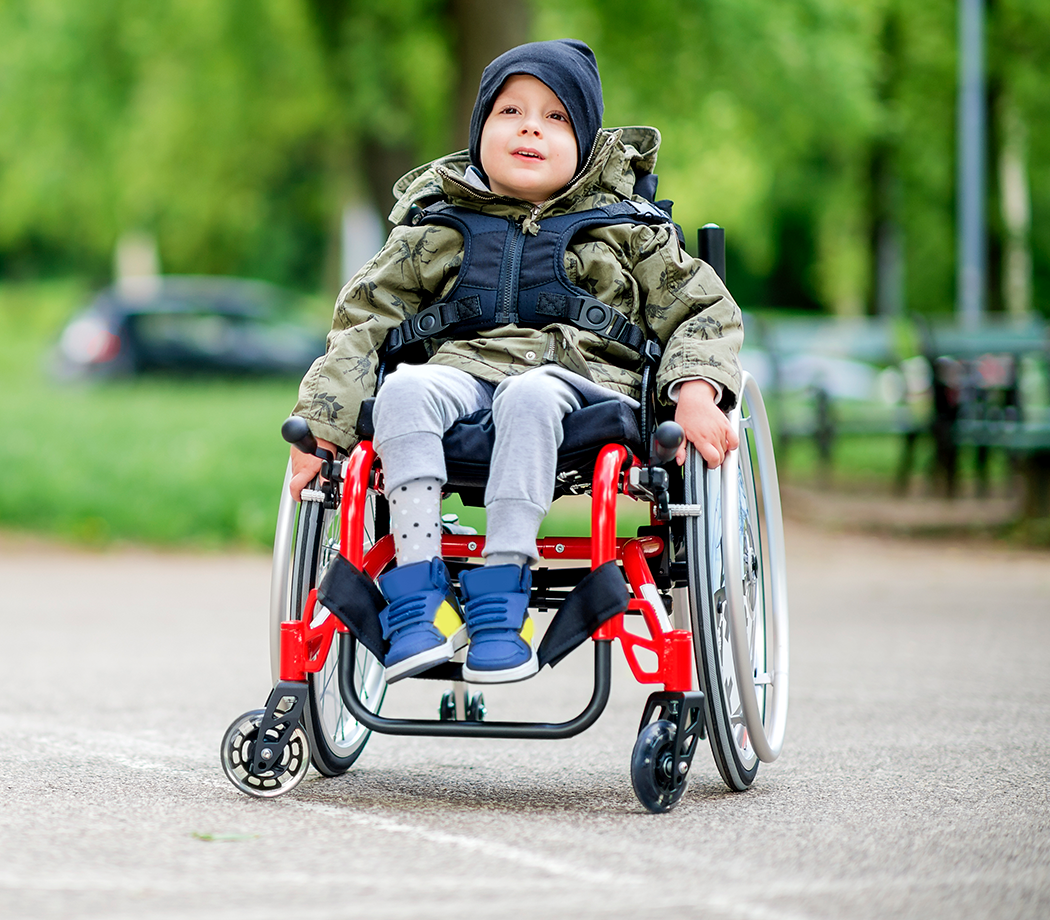 Young cute smiling boy in wheelchair